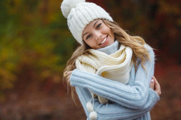 Very beautiful young woman on the autumn background. Close up portrait of smiling young pretty girl in the fall time.