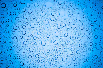 Rain droplets on blue glass background, Water drops on glass.