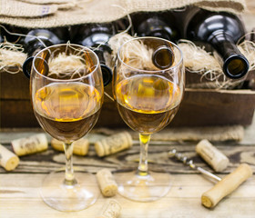 Two glasses of white wine on a wooden background.
