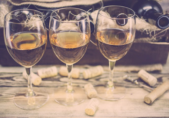 Three glasses of white wine on a wooden background. Alcoholic beverages background