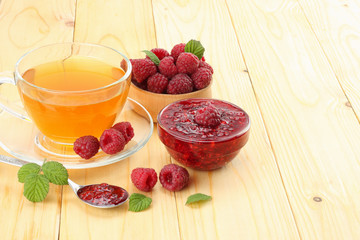 healthy background. raspberry with raspberry jam and tea on light wooden table