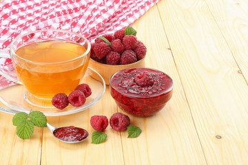 healthy background. raspberry with raspberry jam and tea on light wooden table