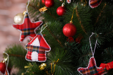 Christmas green pine tree decorated with red colourful toys stars balls sox and horse in studio shoot scene of new year holiday decorations