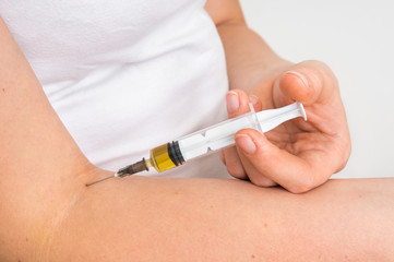 Woman is giving herself vaccine injection