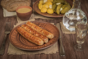 Grilled Bavarian sausages and salad with pickles and pickled patissonov of vodka. German food concept.