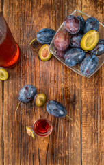 Wooden table with Plum Liqueur, selective focus