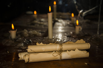 Mysterious ancient scrolls on the table with candles.