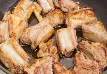 Fried pork ribs in the frying pan