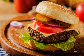 Homemade, beef hamburger with cheese and vegetables.