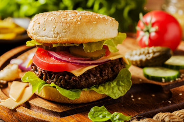 Homemade, beef hamburger with cheese and vegetables.