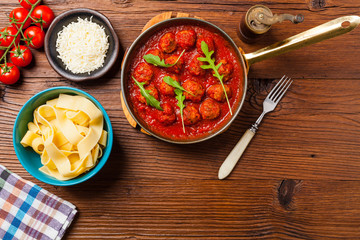 Italian pasta pappardelle with meatballs in tomato sauce.