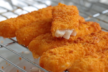 Breaded fish fingers on a grill
