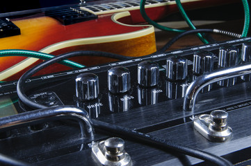 Guitar and stompbox laying there on the stage