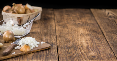 White Onions (dices) on wooden background; selective focus