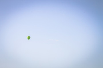 One hot-air balloon flying over the blue sky