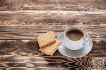Coffee cup and cookie on wood