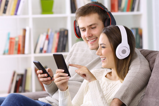 Happy couple listening to music on line at home