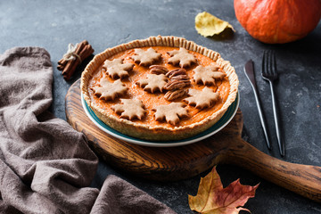 Homemade Pumpkin Pie for Thanksgiving table dinner menu on a wooden cutting board. Side view, selective focus