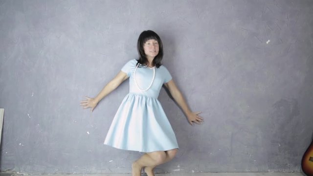 lonely young attractive woman in blue dress laughs and dances