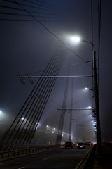 Obraz premium Bridge and traffic under lanterns in the mist during night.
