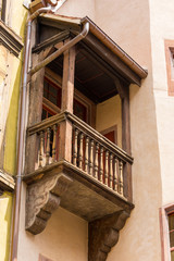 Fototapeta na wymiar Kleiner Balkon aus Holz an einem alten Fachwerkhaus in der französischen Stadt Colmar im Elsass.