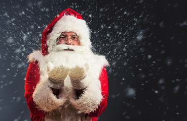 Santa Claus blowing snow of his hands