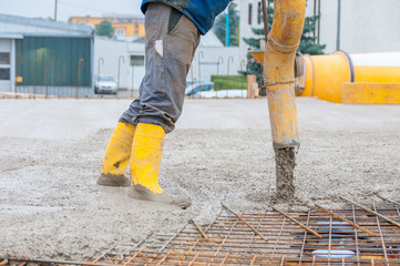 pouring concrete on steel iron fence