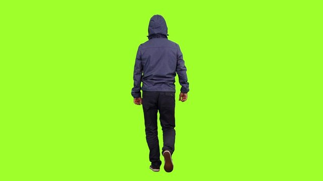 Back view of a hooded man walks on green screen background, Chroma key