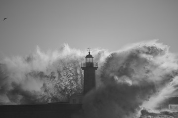 Lighthouse in the middle of stormy waves splash