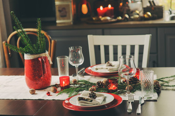 Table setting for celebration Christmas and New Year Holidays. Festive traditional red and green table at home with rustic details