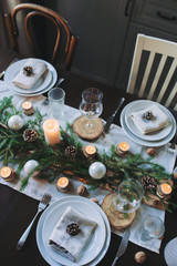 Festive Christmas and New Year table setting in scandinavian style with rustic handmade details in...