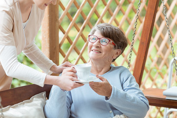 Smiling elder with cup of tea