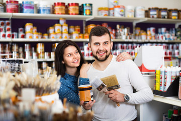 Couple purchasing tools for house improvements in paint supplies store