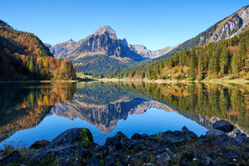 Fototapeta na wymiar Wasserspiegelung Obersee Herbst Herbstwald Brünnelistock blauer Himmel Schatten Licht 