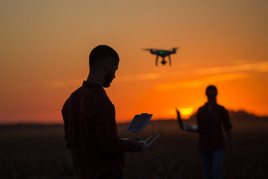 Man navigating drone above farmland
