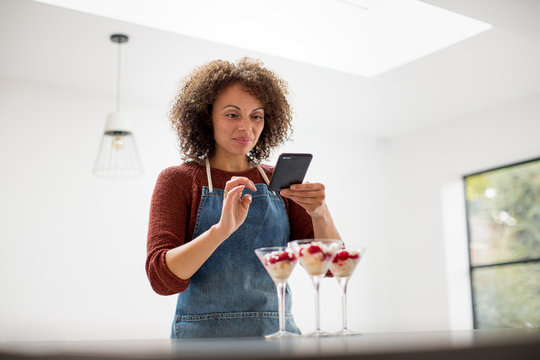 Female food blogger posting a photo with smartphone