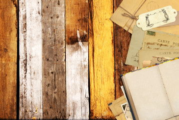 Old book and vintage postcards on old wooden planks