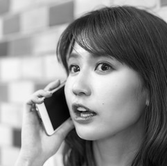 Beautiful asian young girl smiling speaking at the phone