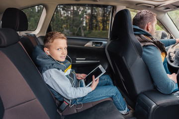 boy with digital tablet in car