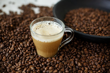 Glass cup of coffee and coffee beans