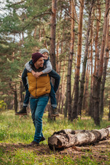 Naklejka premium father piggybacking son in forest