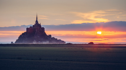 Panoramic view of famous Le Mont Saint-Michel tidal island in beautiful sunrise foggy light, Normandy, northern France