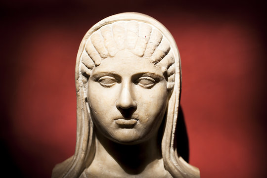 Busto romano femenino sobre fondo rojo