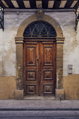Old wooden vintage front entrance door in small two floors building at Nicosia (Lefkosia), Cyprus