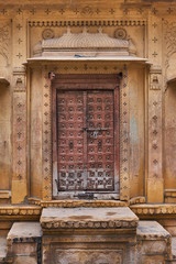 Old wooden vintage front entrance door in Indian haveli at Jaisalmer town