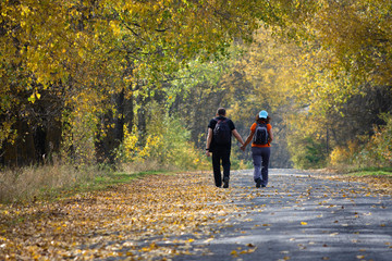 Fototapeta premium Happy expectant parents walking in the autumn forest