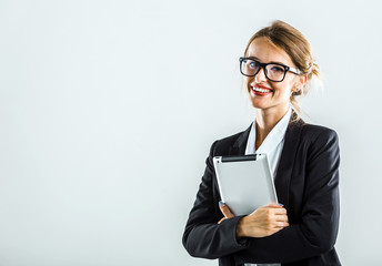 Young caucasian businesswoman with glasses, in a white blouse and a black jacket, is using tablet in the white isolated background