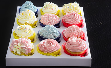 Set of different delicious homemade cupcakes in paper delivery box. Top view.