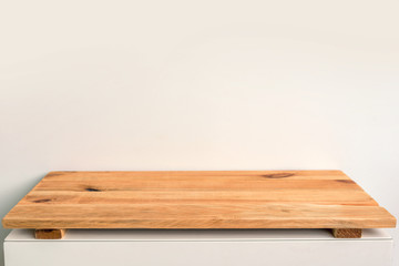 Empty wooden shelf on a white wall, backdrop ready to use for display or montage of your products
