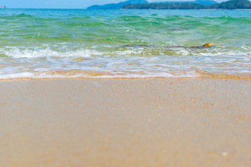 Fototapeta na wymiar Soft Wave Of Blue Ocean On Sandy Beach. Background. Selective focus